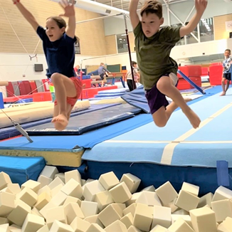 Boy and girl jumping into the foam pit in the HBF Stadium gymnastics training centre