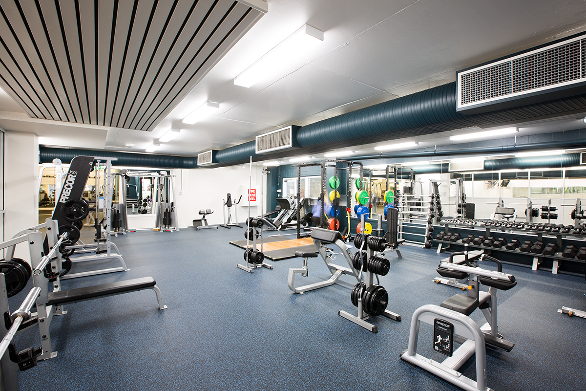 A photo of an active area with free weights and benches spread around
