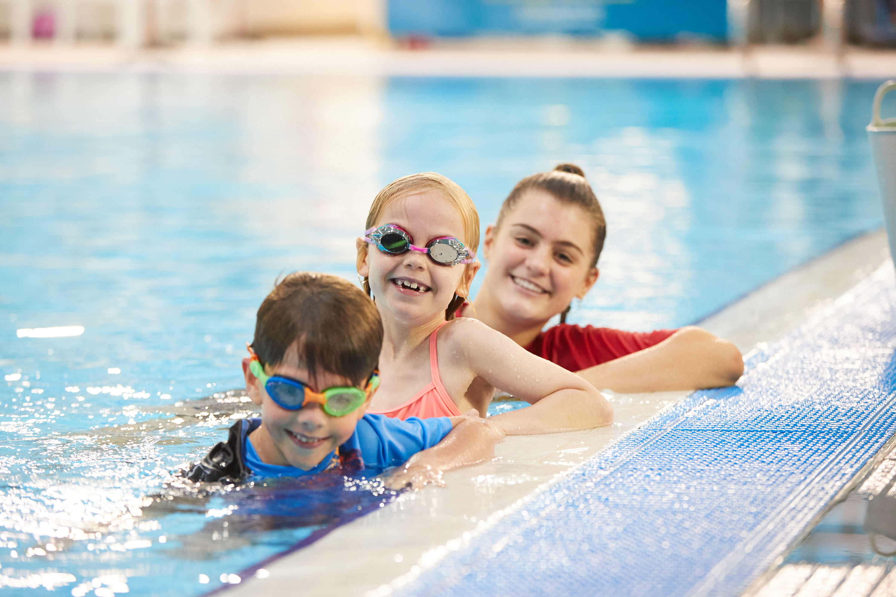 Two children and a teacher lined up in the pool at HBF Stadium in Mount Claremont